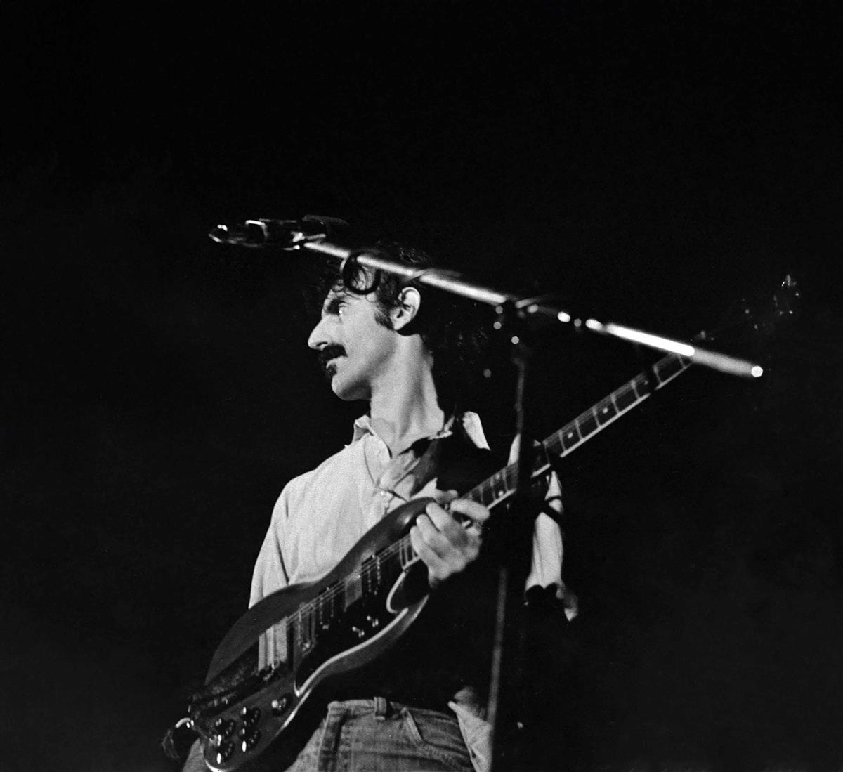 Bilete av Frank Zappa på scena. Foto i fargar.