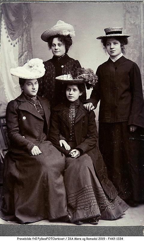 Fire kvinner med hatt og ytterklede. - Klikk for stort bilete