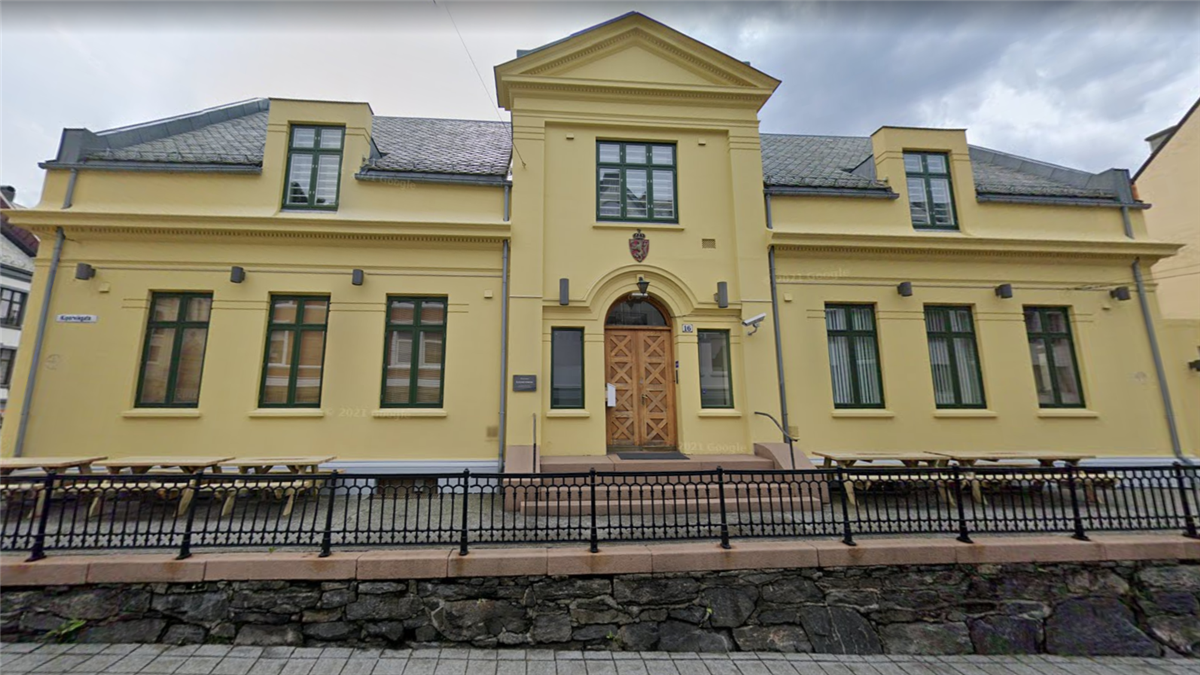Foto i fargar av fasaden til Ålesund fengsel. Gul murbygning. - Klikk for stort bilete
